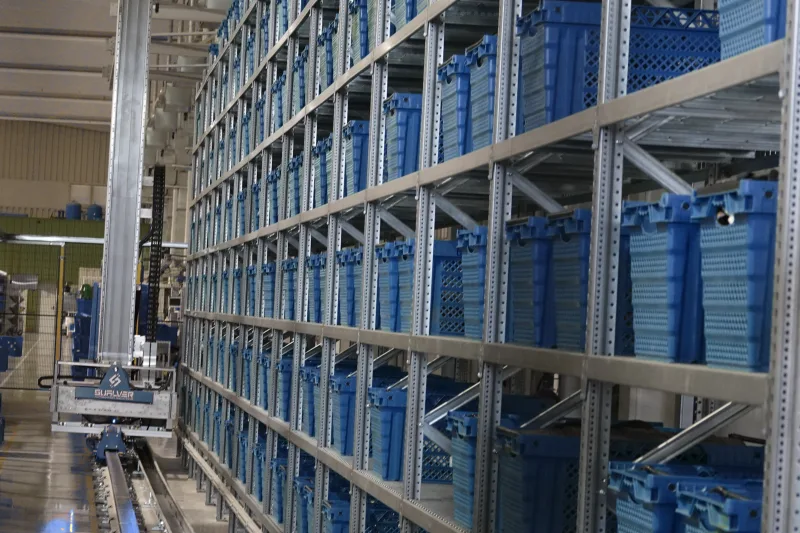 Pasillo del almacén automático con el transelevador en movimiento